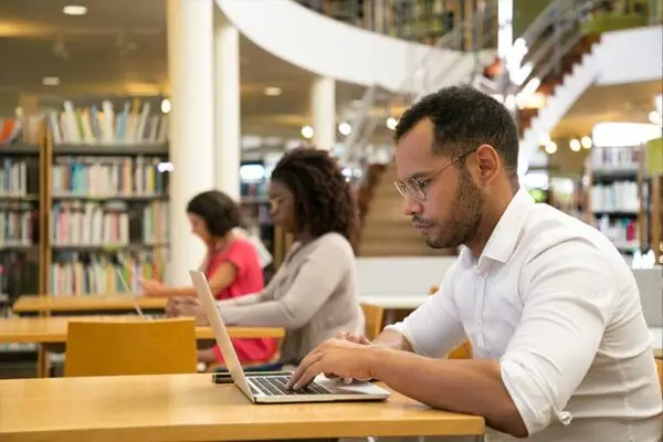 Adults using computers in the library