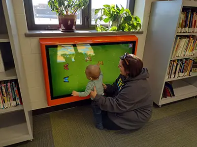 adult holding standing baby in front of Touch2Play Kidzpace
