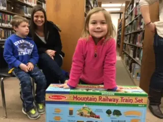 toddler posing with toy mountain railway train set