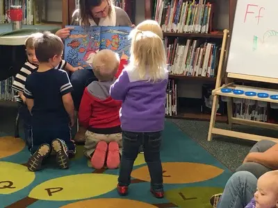 toddlers looking at a picture book in the library