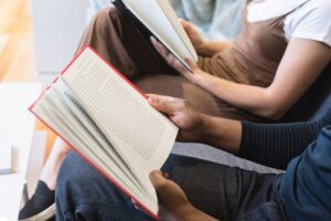 people sitting next to each other reading books