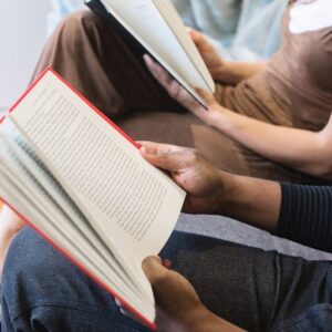 people sitting next to each other reading books